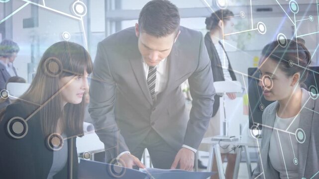 Man leaning over blue folder pointing to pages, team reviewing, data overlay showing business info