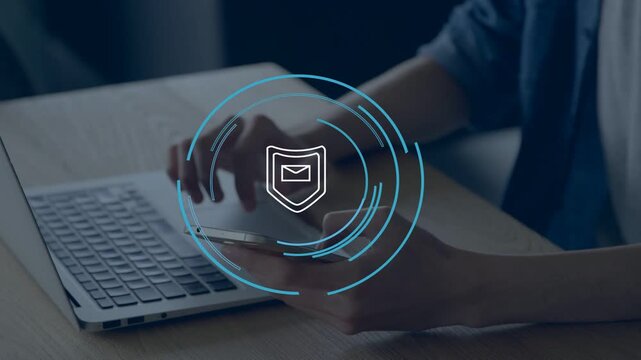 Man hovering over laptop and tapping phone, faint shield with rings forming and securing mail