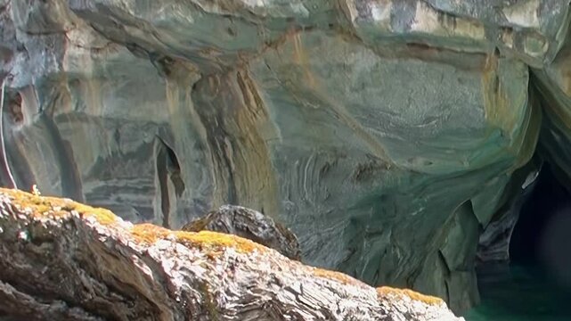 Ethereal Marble Caves in Patagonia reveal nature's grand artistry. Sunlit marble walls show incredible swirling patterns above tranquil turquoise water. A truly majestic sight.