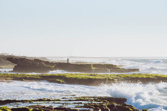 Traditional coastal fishing at the secret spot of Ain Beida, Dakhla, featuring vibrant green reefs and a misty Atlantic