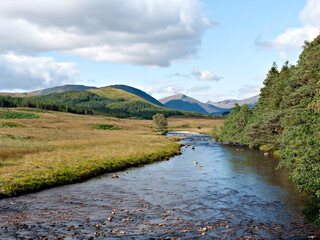 Fototapeta premium The view west from the West Highland Way on Rannoch Moor at Victoria Bridge of the Abhainn Shira river, Beinn Suidhe, Beinn nan Aighenan and Ben Starav. Argyll, Scottish Highlands.