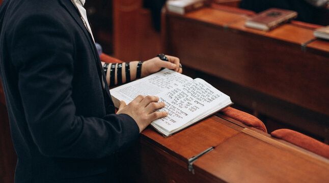 Jewish Prayer with Tefillin and Open Torah