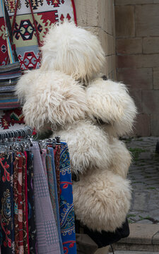 Traditional Azerbaijani sheepskin papakha hats and colorful silk scarves at souvenir market stall in Baku old city