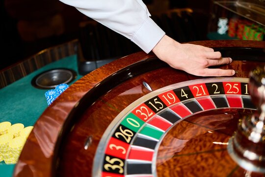 Casino Roulette Wheel Close Up with Dealer Hand