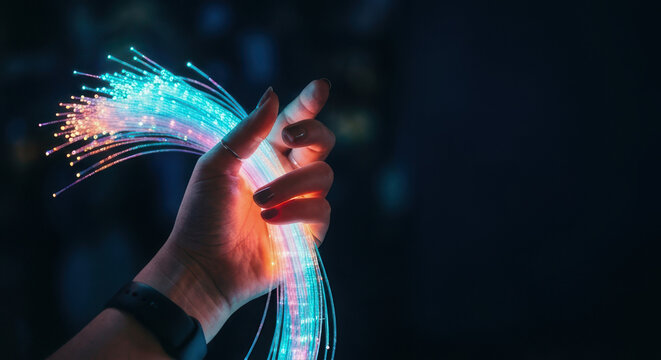 Hand holds vibrant fiber optic cables showcasing technology and innovation in AI and software