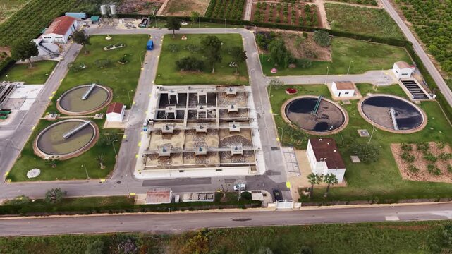 Aerial view of modern wastewater treatment facility showing circular clarifiers, bioreactor aeration basin with activated sludge, and biological nitrogen and phosphorus removal systems