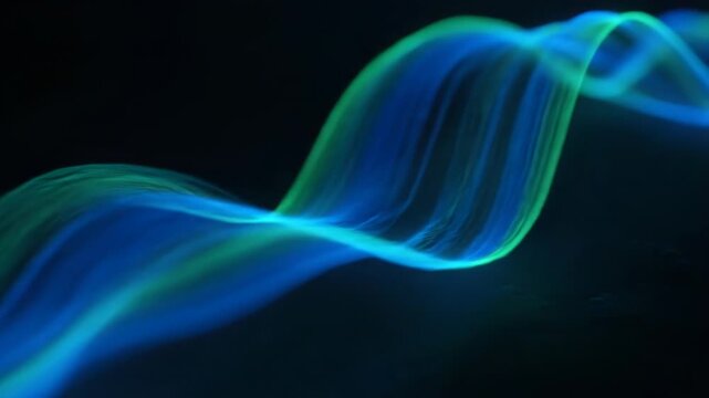 Abstract flowing blue and green light trails move gracefully across a dark background. This ethereal visual evokes a sense of motion and wonder.