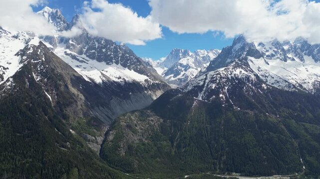 Wide cinematic drone panorama of the Mer de Glace glacier surrounded by dramatic snowy peaks and alpine landscapes in the Chamonix valley, France, captured from above in the heart of the French Alps.