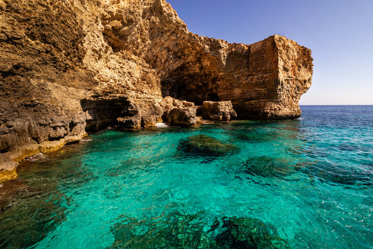 Turquoise water and limestone cliffs at Ghar ic-Comb sea cave in Mellieha Malta