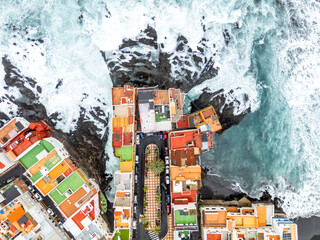 Aerial view photo from above wild waves in the Atlantic Ocean with colorful houses on Tenerife island in Puerto de la Cruz, Spain © Markus Mainka