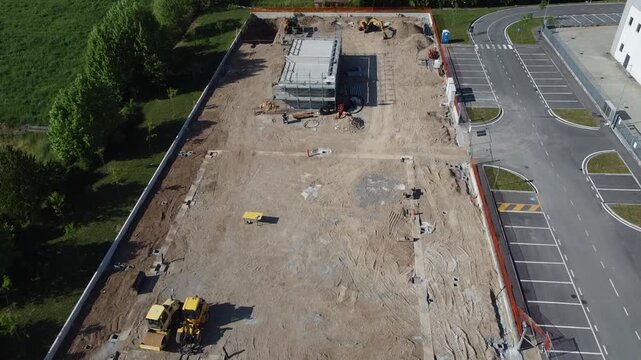 Aerial view of a construction site with heavy machinery and building foundations under development.