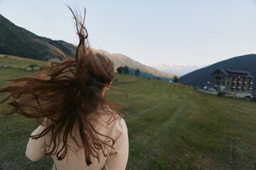 Naklejka premium A woman lifestyle outdoor countryside field wind hair meadow portrait in a sunlit landscape. A dynamic, carefree moment capturing freedom, exploration, and connection with nature.