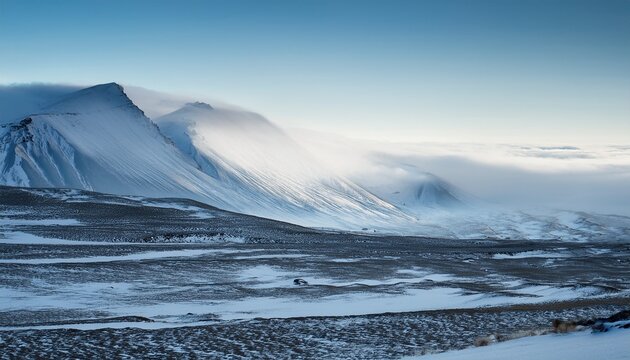 view of snow covered mountains shrouded in a misty veil a stark landscape where earth meets sky in a dance of muted tones blonduos iceland