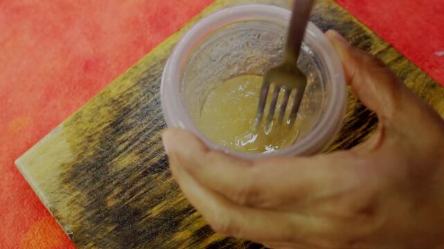 Person mixing ingredients for ceviche on a wooden board, close-up