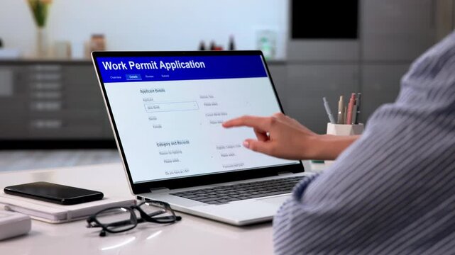 Woman Filling Out Work Permit Application Form Online At Home