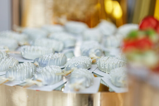 Elegant White Chocolate Glazed Cakesicles with Sugar Sprinkles on Banquet Table