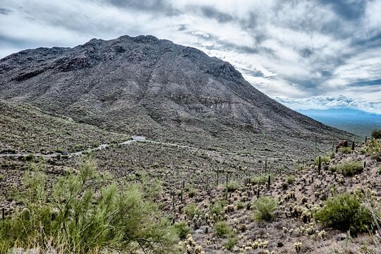  Arizona Desert Mountain Landscape with Rocky Terrain and Saguaro Cactus Covered Hillside Under Cloudy Sky