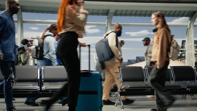 Commuting, runway control tower and multiethnic men with women in airport transport hub. Walking, metal chairs and multiracial travelers inside flight departure terminal, camera A