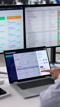 Procurement Manager Reviews Supplier Data On Multiple Screens