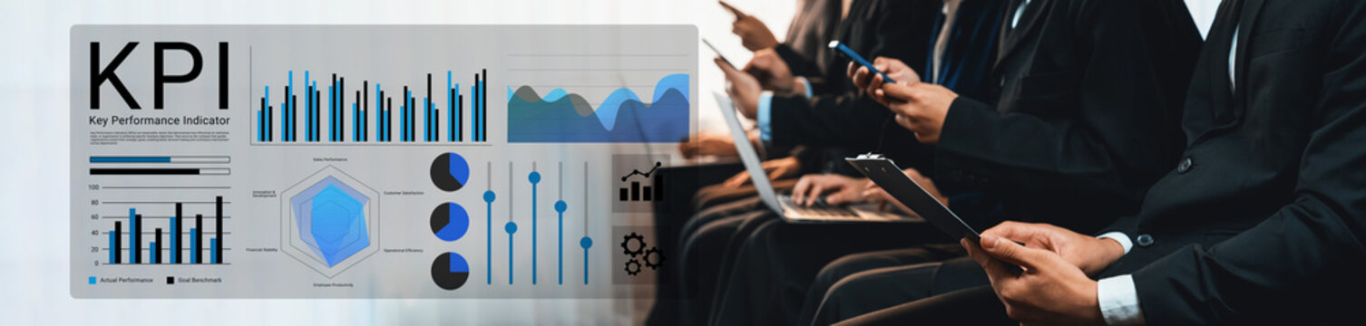 Various business professionals are engaged in analyzing Key Performance Indicators with digital devices while reviewing graphs and statistics in a modern corporate setting. Gantry