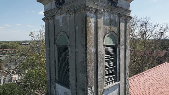 Drone shot slowly ascending next to the historic Reformed Calvinist Church tower in Vrbas, Serbia. Close-up video.