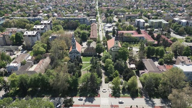 Aerial view descending towards historic churches in Vrbas town center, northern Serbia.