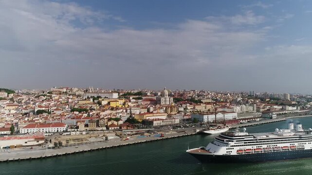 Cruise boat on the banks of the Tejo River with the historic city of Lisbon in the background.