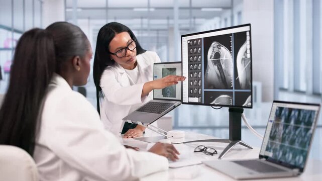 Doctor And Technician Reviewing MRI And X-ray Images