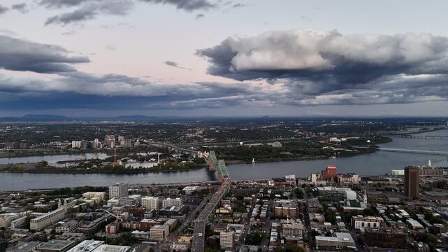 Jacques Cartier Bridge over the Saint Lawrence River at sunset, Montreal, Quebec, Canada skyline and dramatic clouds. g.