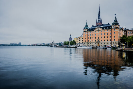  Stockholm Sweden Strandv&auml;gen Waterfront with Historic Hotel Diplomat Building Reflected in Calm Water Under Overcast Sky