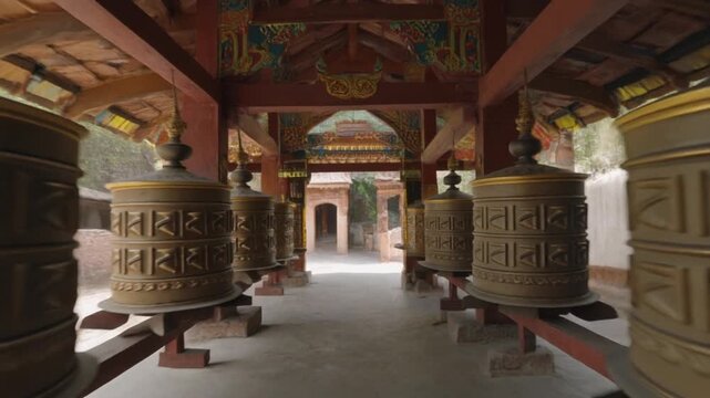 Buddhist Prayer Wheels Lined in Traditional Himalayan Temple Corridor