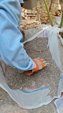 Sifting sand manually using a traditional mesh and gloves