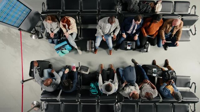 Top down view of frustrated passengers in airport agitated by gate agent giving bad news of delayed flights. Annoyed group of multiethnic people reacting to flight cancellation announcement