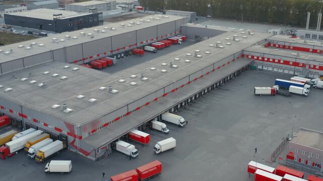 Aerial Drone View of Large Logistics Park with Red Trailers at Loading Docks | Modern Freight Distribution and Sorting Complex | Supply Chain and Cargo Hub Overview