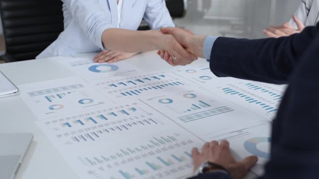 Business executives shaking hands, sealing an agreement after successful negotiations in a bright office, symbolizing partnership, collaboration, and a mutually beneficial deal signing