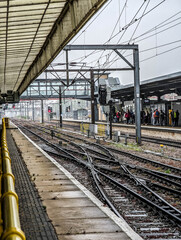 Obraz premium Railway Tracks and Passenger Platforms at Cambridge Train Station Under Overcast Sky in England