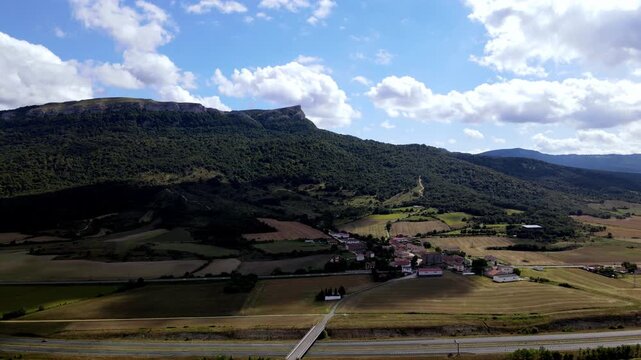 Aerial view of San Roman village in Alava, Basque Country, Spain. Drone rising over a small rural town at the foot of the mountains.