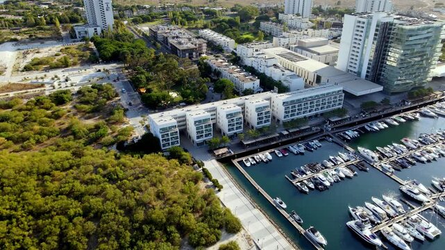 Aerial view of Troia Marina and luxury resort hotels, Portugal. Drone flying from the river side towards the waterfront and modern buildings at sunset.