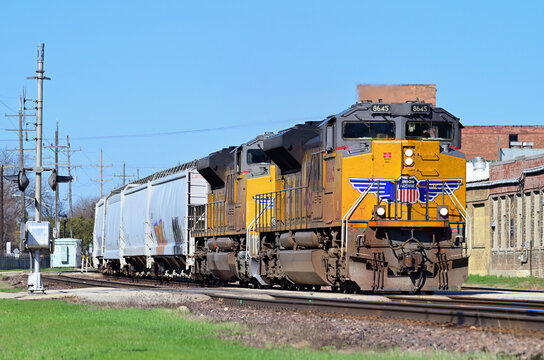 Multiple locomotives lead a Union Pacific Railroad freight train through a suburban Chicago community.