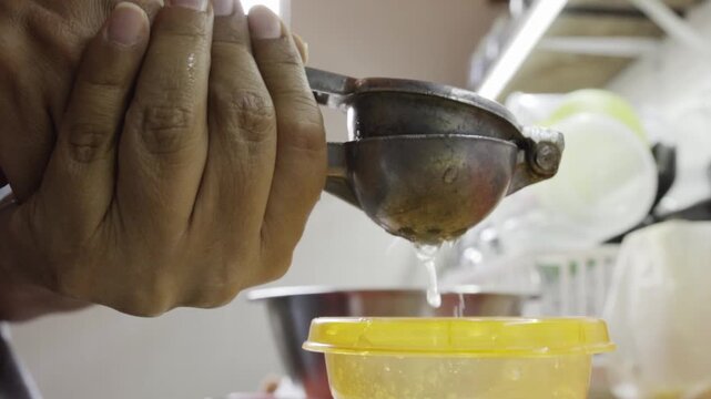 Hand squeezing lemon for albondigas de pollo preparation