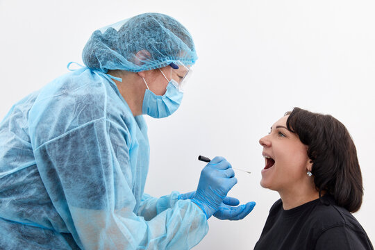 Doctor in a protective suit taking a throat and nasal swab from a patient to test for possible coronavirus or covid infection
