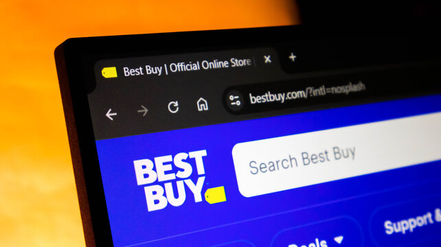 Closeup of the best buy website homepage displayed on a laptop screen, showing the company logo, search bar, and browser interface