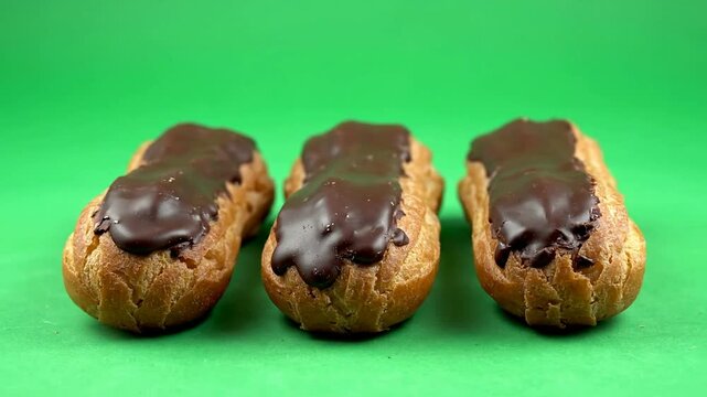 Three Isolated Chocolate Eclairs On Green Screen Background For Culinary Presentations And Dessert Advertisements