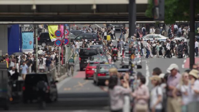 Busy tokyo street scene with pedestrians crossing and urban city traffic