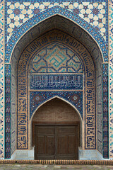 Obraz premium Ornate portal of Bibi Khanym Mosque in Samarkand featuring intricate tilework and Arabic calligraphy. Ideal for travel guides, cultural publications, and architectural references.