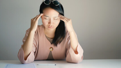 A beautiful office lady is tired from migraines while working, working too hard and stressed for work deadlines, and has office syndrome © Ople