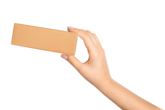 Hand holding small brown cardboard box on white background, minimal packaging and delivery concept