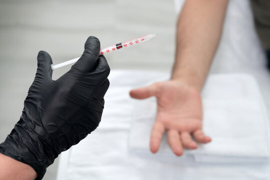 doctor makes a shot of botulinum toxin in the hand of a male palm against excessive sweating, treatment of hyperhidrosis