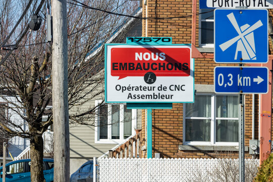 Quebec, Canada, 24 April 2026 : A red and white sign advertises job openings for CNC operators and assemblers on a street.