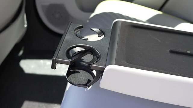 Modern electric vehicle center console in Avatr 11 with integrated cup holders and wireless phone charger. Great for lifestyle, convenience, and automotive technology content.